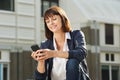 Happy woman with cellphone sitting outside Royalty Free Stock Photo