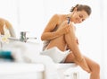 Happy woman checking legs after shaving Royalty Free Stock Photo