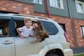 Happy woman and child look out of a car window. Cheerful boy with his mother are sitting in the back seat of the car and Royalty Free Stock Photo