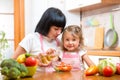 Happy woman and child preparing healthy food together