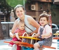 Happy woman with children on swings Royalty Free Stock Photo