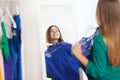 Happy woman choosing clothes at home wardrobe