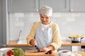 happy woman chopping red onion on kitchen