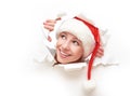 Happy woman with christmas hat peeking through a hole torn in white paper poster