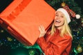 Happy woman Christmas. Woman new years eve. Blonde girl holding a huge box with gifts for New Year. We wish you a merry Royalty Free Stock Photo