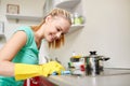 Happy woman cleaning cooker at home kitchen