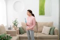 Happy woman cleaning home, singing at mop like at microphone and having fun Royalty Free Stock Photo