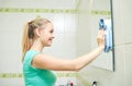 Happy woman cleaning mirror with rag Royalty Free Stock Photo