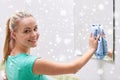 Happy woman cleaning mirror with rag Royalty Free Stock Photo