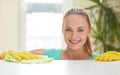 Happy woman cleaning table at home kitchen