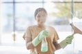 Happy, woman and cleaning window with smile, spray bottle and soap or detergent housekeeping in home or hotel. Housework Royalty Free Stock Photo