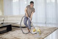 Happy woman cleans carpet with a vacuum cleaner Royalty Free Stock Photo