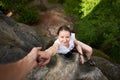 Beautiful young woman climbing on rock outdoors in summer. Top view. Happy girl climbing rock trekking outdoors