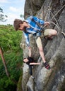 Happy woman climbing rock trekking outdoors. Carefree hiker smiling her friend. Friendly helping hand