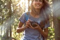 Happy woman closeup with vintage camera walking on hiking trail path in forest woods during sunny day.Group of friends Royalty Free Stock Photo