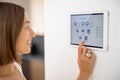 Happy woman controlling smart devices using control panel at kitchen Royalty Free Stock Photo
