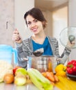 Happy woman cooking veggie soup