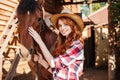 Happy woman cowgirl with her horse in village Royalty Free Stock Photo