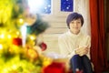 Happy woman with cup of coffee or tea at home over christmas tree Royalty Free Stock Photo