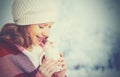 Happy woman with cup of hot drink on cold winter outdoors Royalty Free Stock Photo