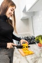 Happy young woman cut pepper for cooking vegetables salad at the kitchen Royalty Free Stock Photo