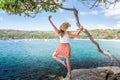 Happy woman dance pirouette beside tree by the ocean Royalty Free Stock Photo