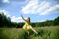 Happy woman dancing on the grass