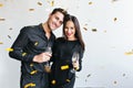 Happy woman with dark straight hair celebrating anniversary with husband. Indoor portrait of cheerful man with glass of Royalty Free Stock Photo