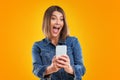 Close up of woman in denim jacket with smartphone over yellow background Royalty Free Stock Photo