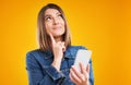 Close up of woman in denim jacket with smartphone over yellow background Royalty Free Stock Photo