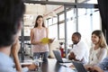 Happy woman with document stands addressing team at meeting Royalty Free Stock Photo