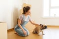 Happy woman with dog and boxes moving to new home Royalty Free Stock Photo