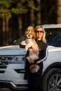 Happy woman and dog in car on summer vacation. Dog and human friendship and travel concept. Relax and enjoy the tranquility of