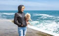 Woman with a doggie of in the early spring near the sea Royalty Free Stock Photo