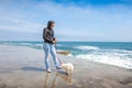 Woman with a doggie of in the early spring near the sea Royalty Free Stock Photo