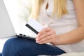 Happy woman doing online shopping at home . Close- up of a hand holding a credit card next to a laptop Royalty Free Stock Photo