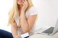 Happy woman doing online shopping at home . Close- up of a hand holding a credit card next to a laptop Royalty Free Stock Photo