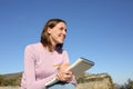 Happy woman drawing on paper notebook looking away in nature Royalty Free Stock Photo