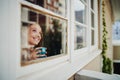 Beautiful young woman smiling drinking coffee and daydreaming enjoying outside view during isolation Royalty Free Stock Photo