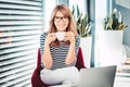 Happy woman drinking coffee while sitting at home and working online Royalty Free Stock Photo