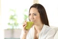 Woman drinking a green vegetable juice at home Royalty Free Stock Photo