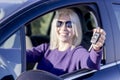 Happy young woman showing keys from her first car - side view Royalty Free Stock Photo