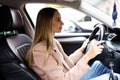 Happy young success happy brunette woman is driving a car. Portrait of happy female driver steering car with safety belt Royalty Free Stock Photo