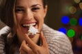 Happy woman eating Christmas cookie