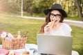 Happy woman eating croissant and using laptop outdoors Royalty Free Stock Photo