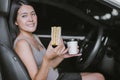 Happy woman eating food and drinking coffee while driving to work in the early morning Royalty Free Stock Photo