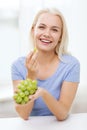 Happy woman eating grapes at home Royalty Free Stock Photo