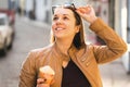 Happy woman eating ice cream and lifting sunglasses. Royalty Free Stock Photo