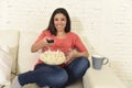 Happy woman eating popcorn watching television at sofa couch happy excited enjoying movie Royalty Free Stock Photo