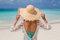 Happy woman enjoying beach relaxing joyful in summer by tropical crystal blue water. Beautiful bikini model from behind wearing Royalty Free Stock Photo